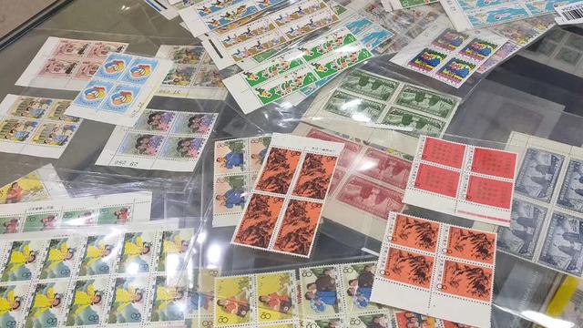 不同題材的郵票與連票放在玻璃檯面上