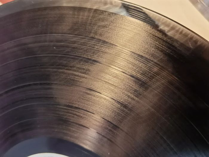一張黑膠唱片因化學反應（黑膠癌）而出現表面霧化的損害特寫