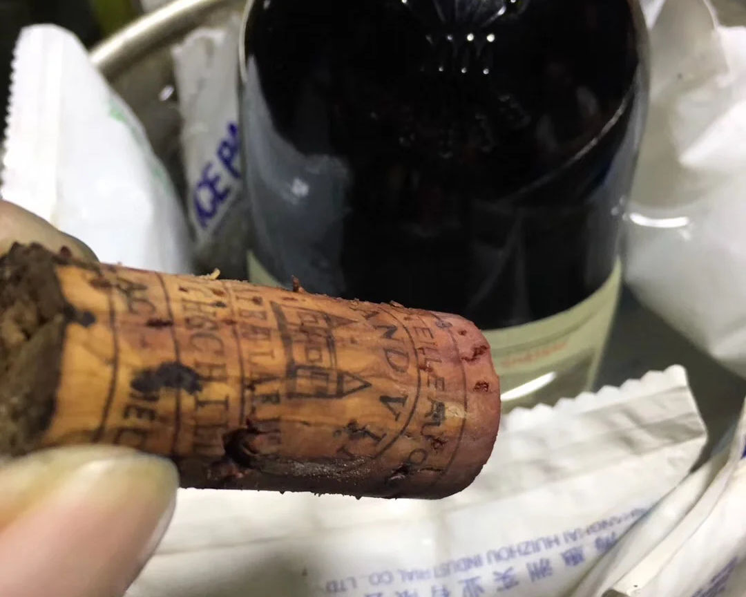 專業鑑定師正在仔細檢查紅酒瓶的軟木塞和封口