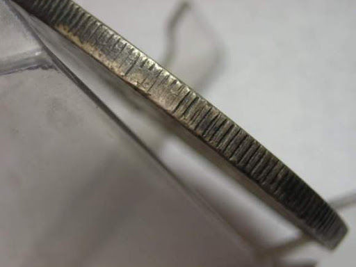 專業鑑定師使用放大鏡檢查銀元的邊齒和圖案細節