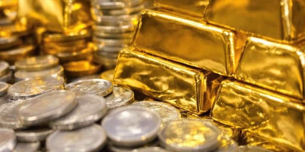 一枚袁大頭銀元與一塊黃金金條並排，突顯兩者的價值差異