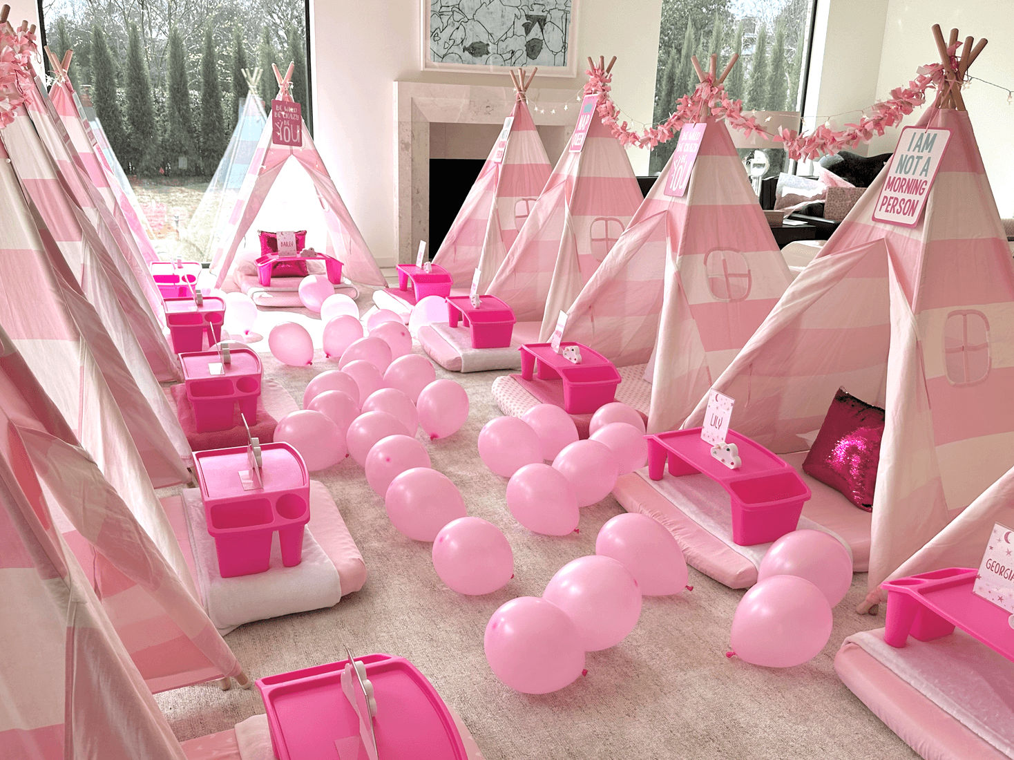 Slumber party and teepee party in a room with a bed and colorful balloons