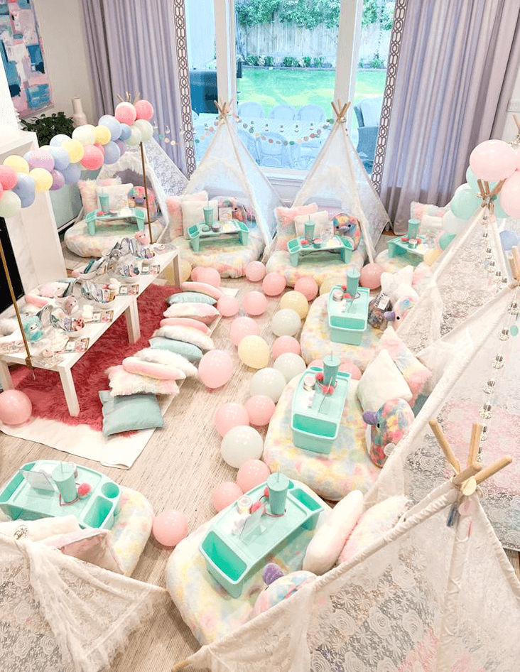 Slumber party and teepee party with a group of balloons on a bed