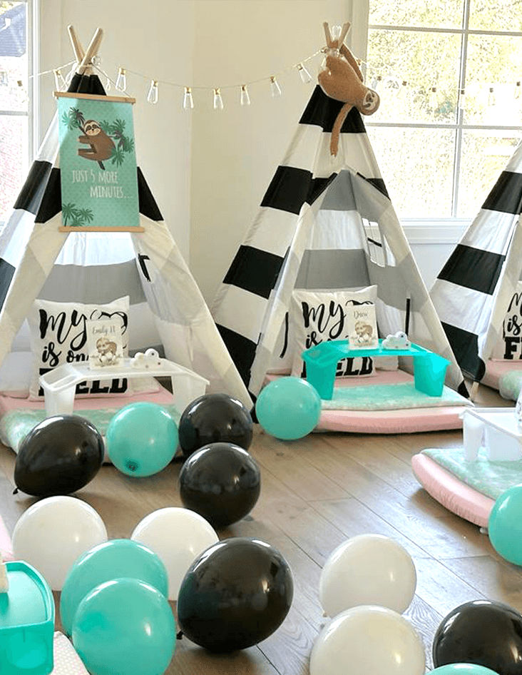 Slumber party and teepee party with a group of balloons on a bed