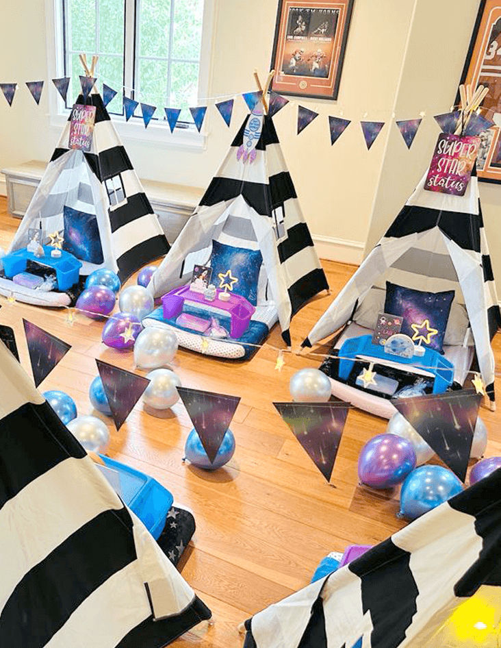 Slumber party and teepee party with a group of balloons on a bed