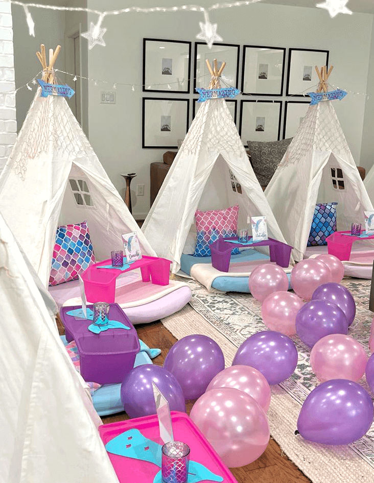 Slumber party and teepee party with a group of balloons on a bed