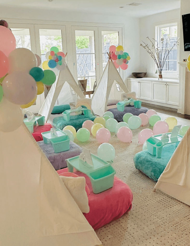 Slumber party and teepee party with a group of balloons on a bed