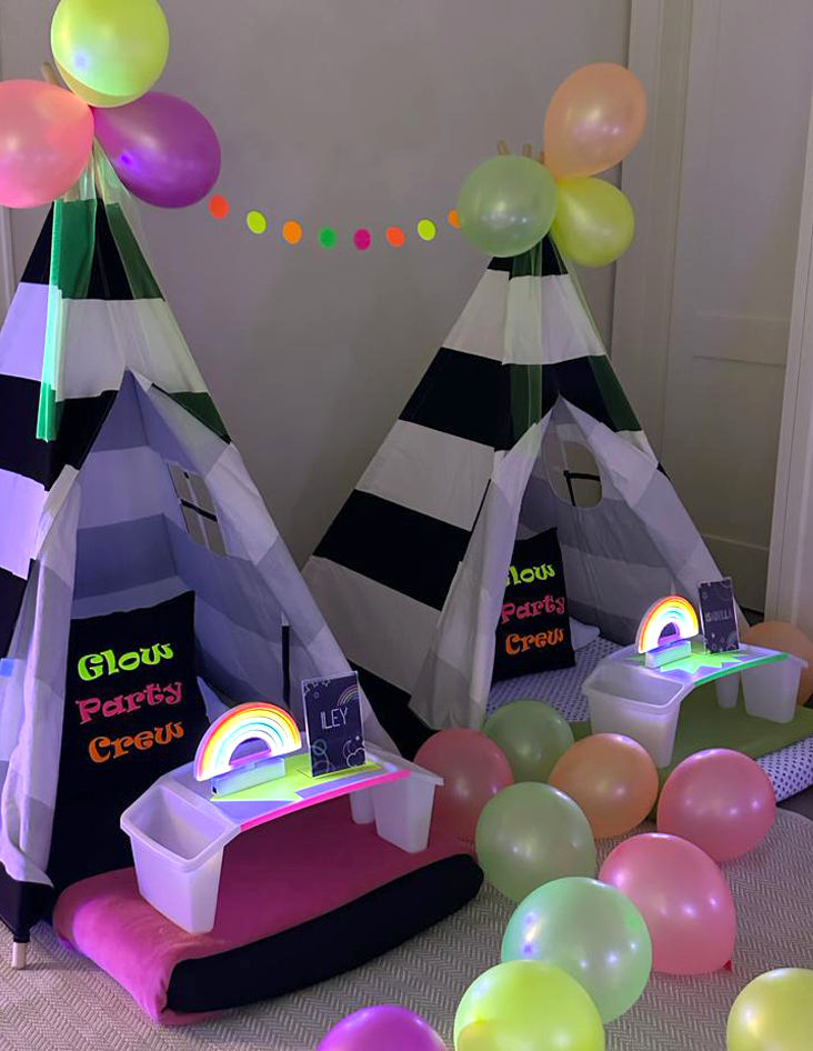 Slumber party and teepee party with a group of balloons on a bed