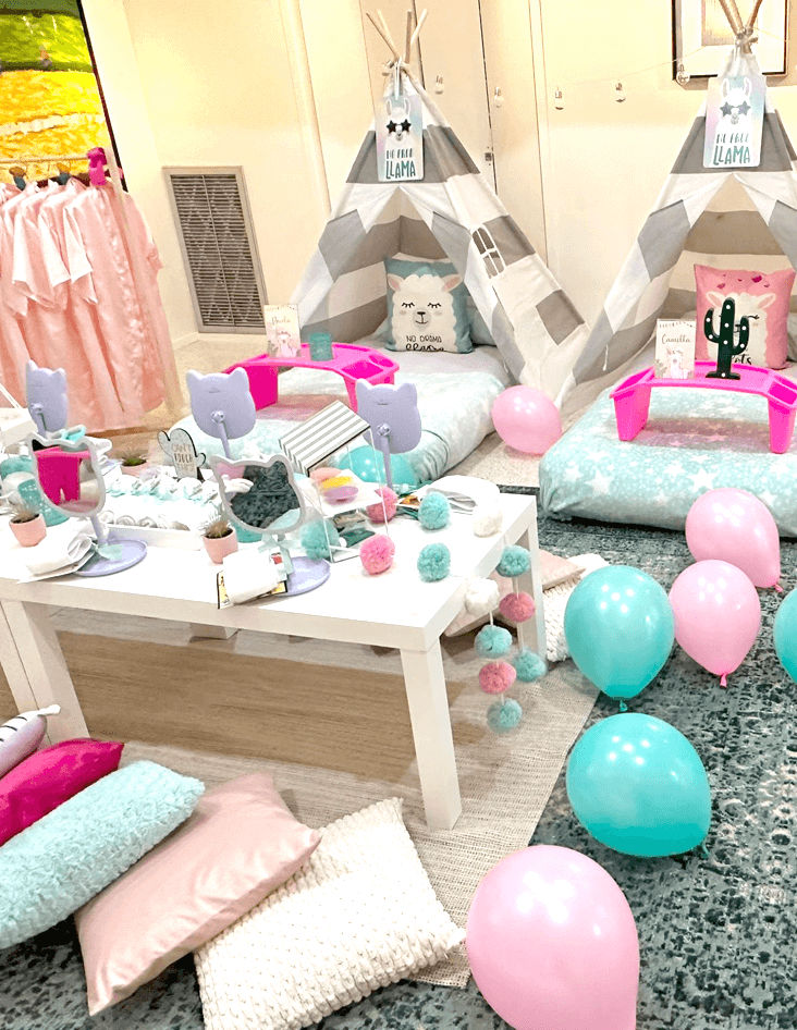 Slumber party and teepee party with a group of balloons on a bed