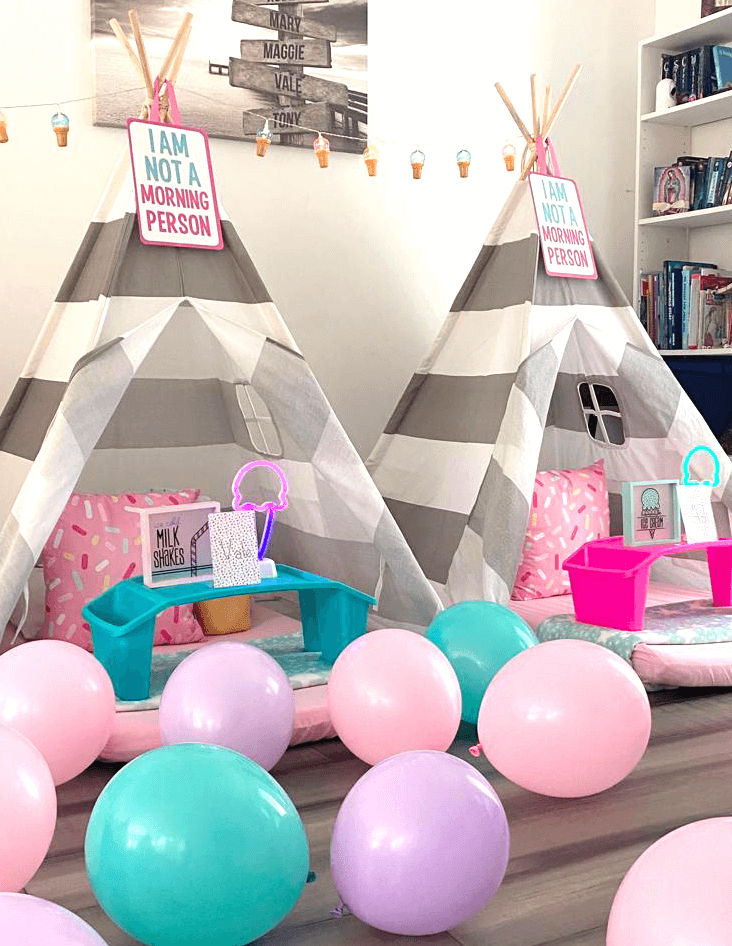 Slumber party and teepee party with a group of balloons on a bed