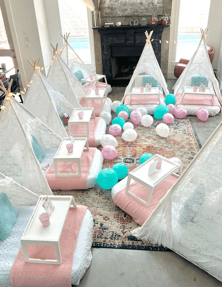 Slumber party and teepee party with a group of balloons on a bed