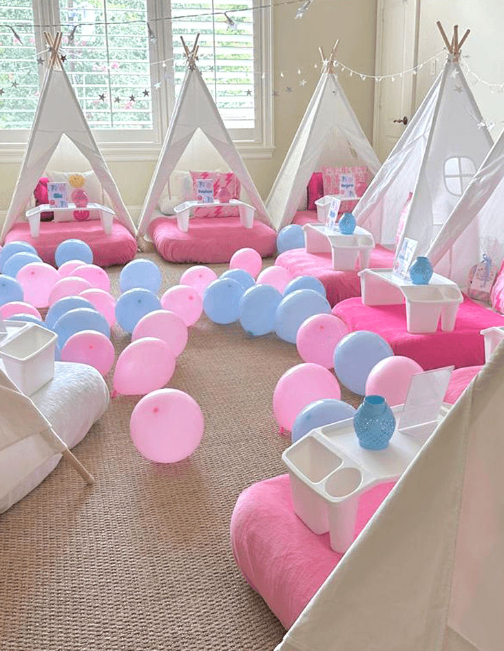 Slumber party and teepee party with a group of balloons on a bed