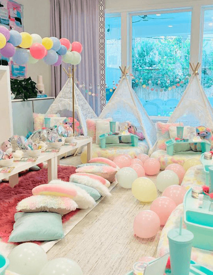 Slumber party and teepee party with a group of balloons on a bed