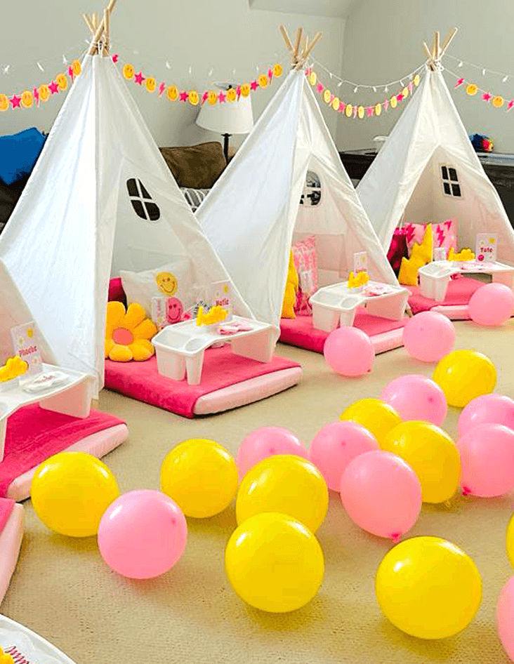 Slumber party and teepee party with a group of balloons on a bed