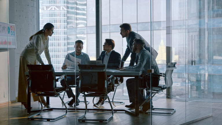 Executives meeting in glass boardroom