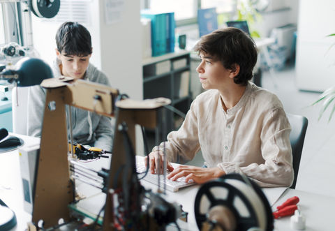 Two people working with a 3D printer