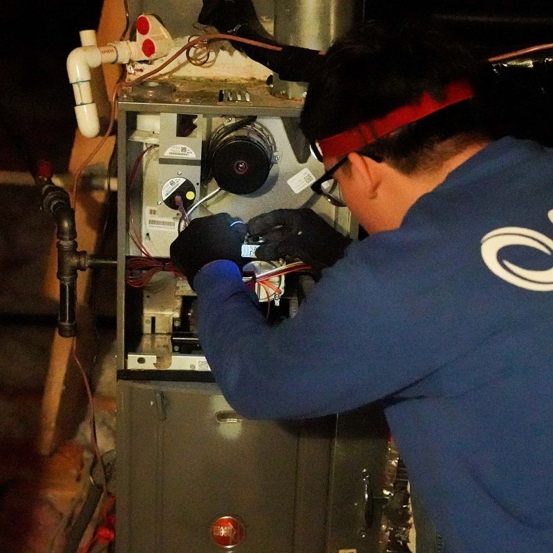 Cool United Air technician checking gas furnace