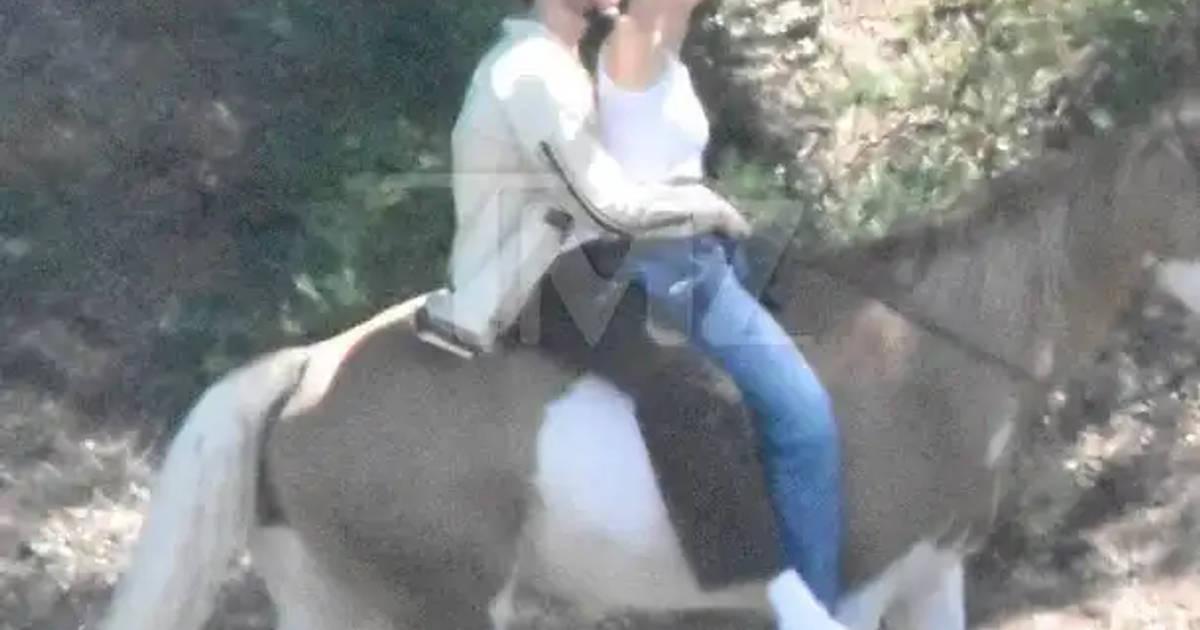 Bad Bunny and Kendall Jenner on a horse taking a photo