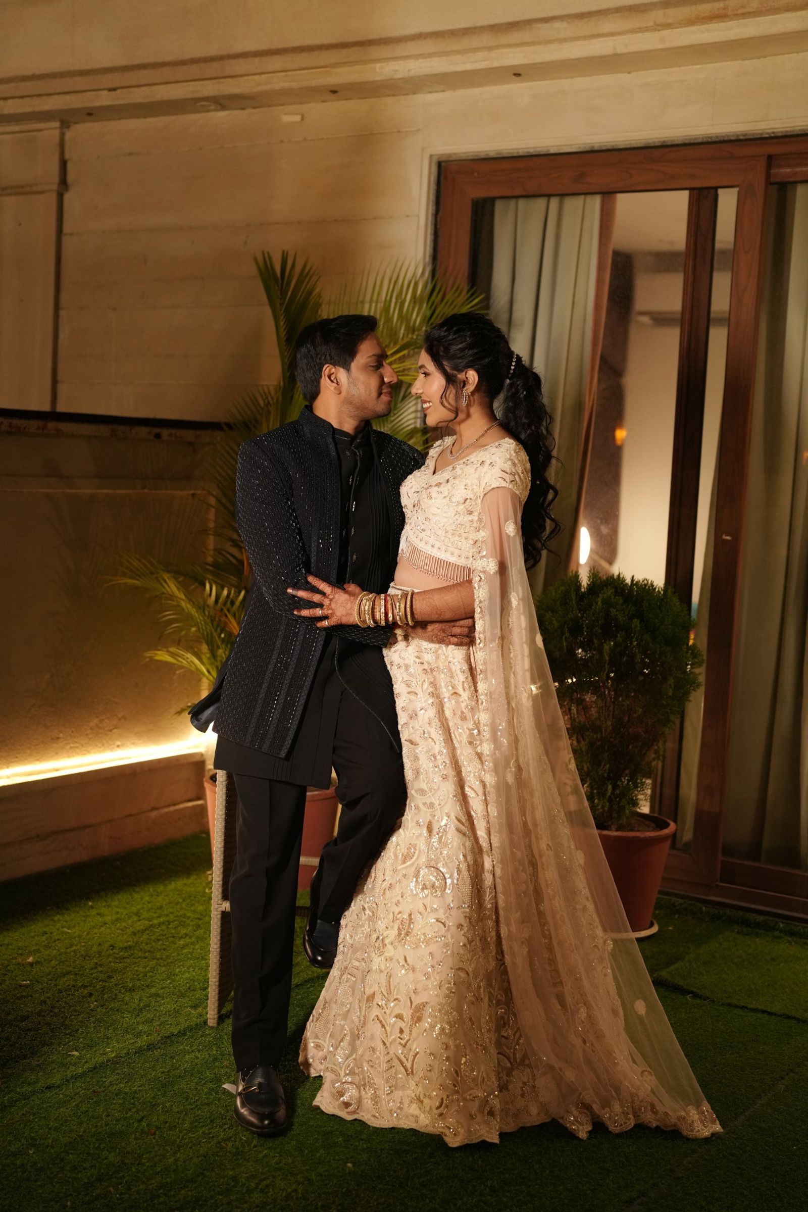 Ravi and Saloni in evening wear, leaning into each other