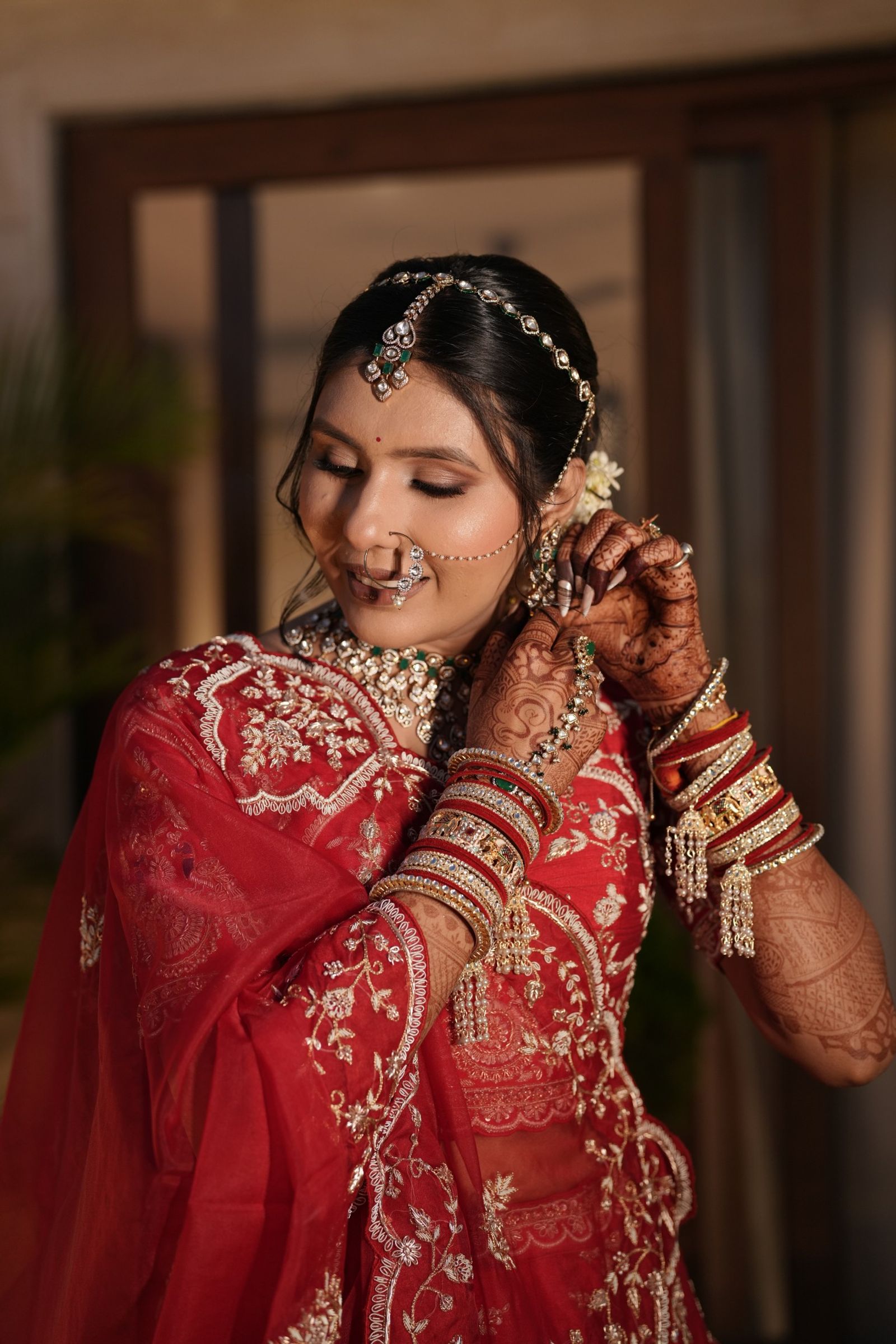 Saloni fixing her earring on the wedding morning