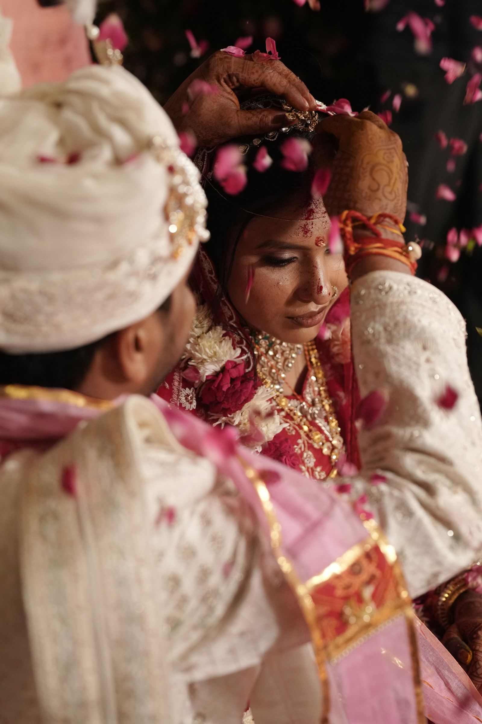 Ravi applying sindoor as rose petals fall