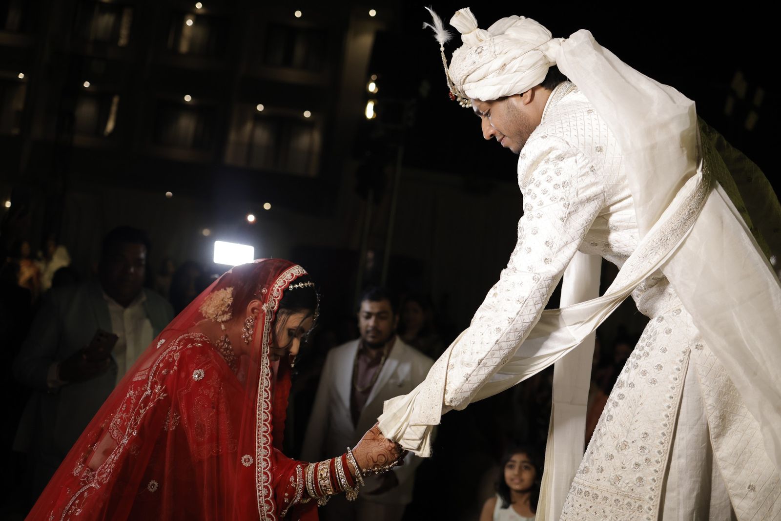 Ravi reaching down to take Saloni's hand
