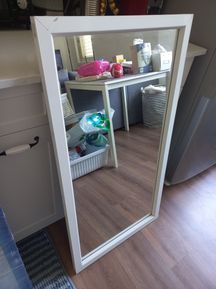 מראה גדולה עם מסגרת אלומיניום לבנה.