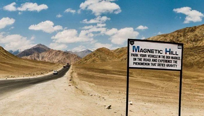 Picture of magnetic hill road and a signboard