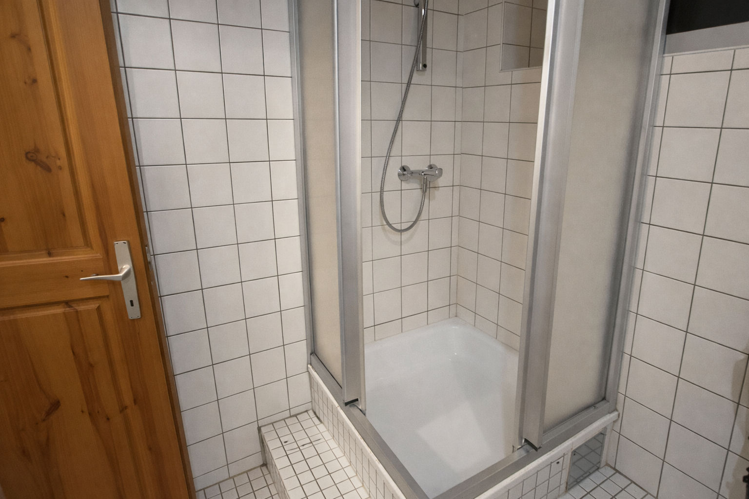 Eckdusche mit Holz- und Metallelementen.png