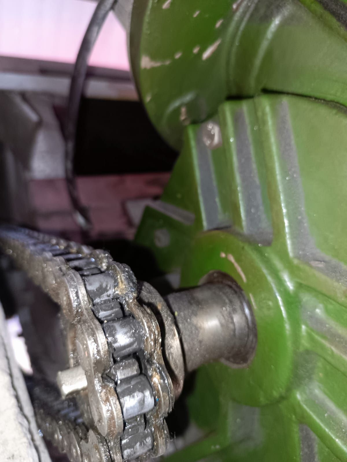 Detalle de un motor y su transmisión por cadena en un sistema de puerta.