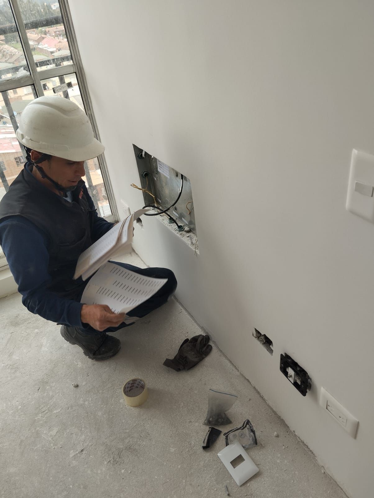 Técnico de EINSPRO revisando un punto de infraestructura con documentación en mano.