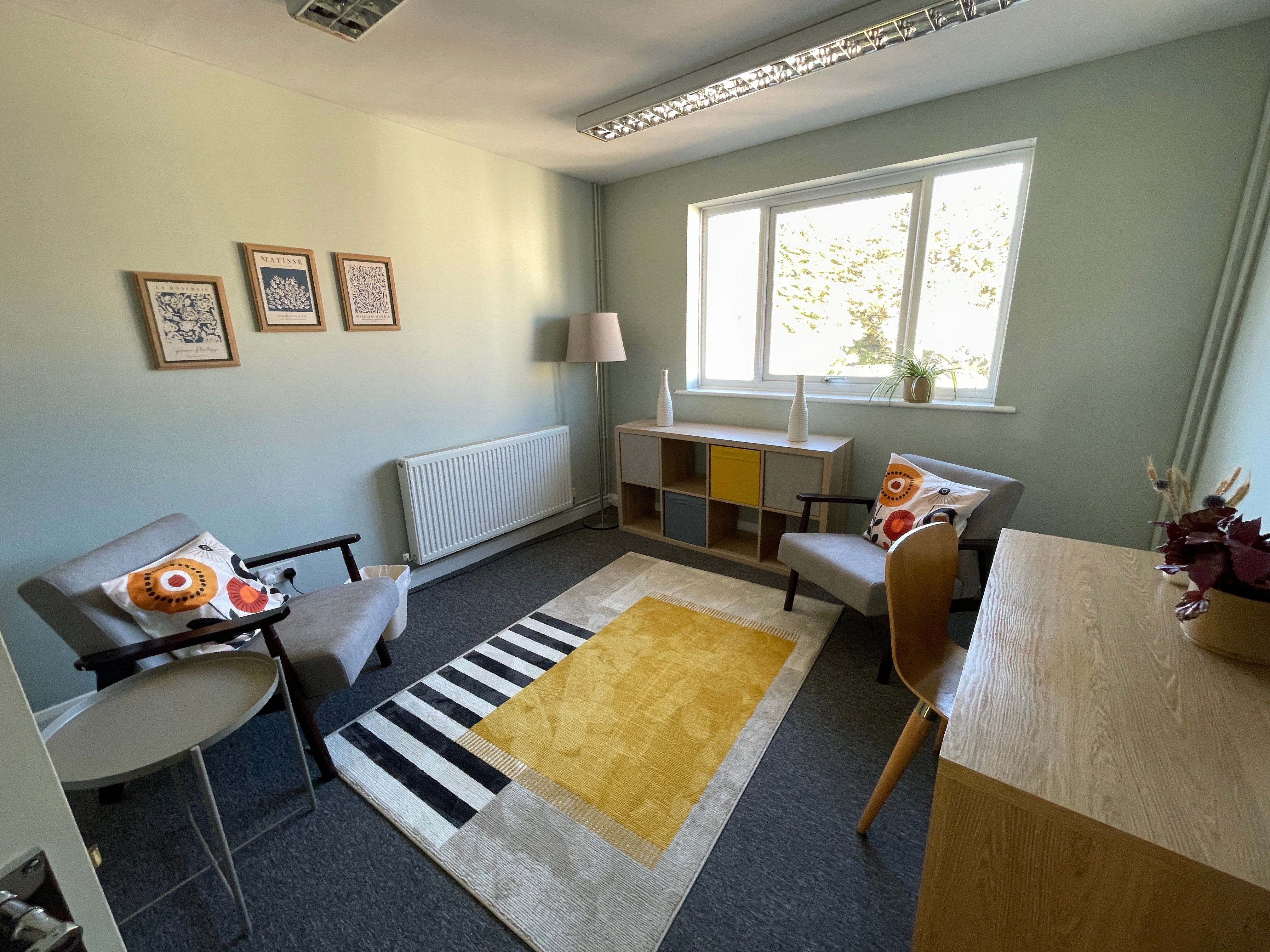 Two chairs in a calm, softly lit counselling room