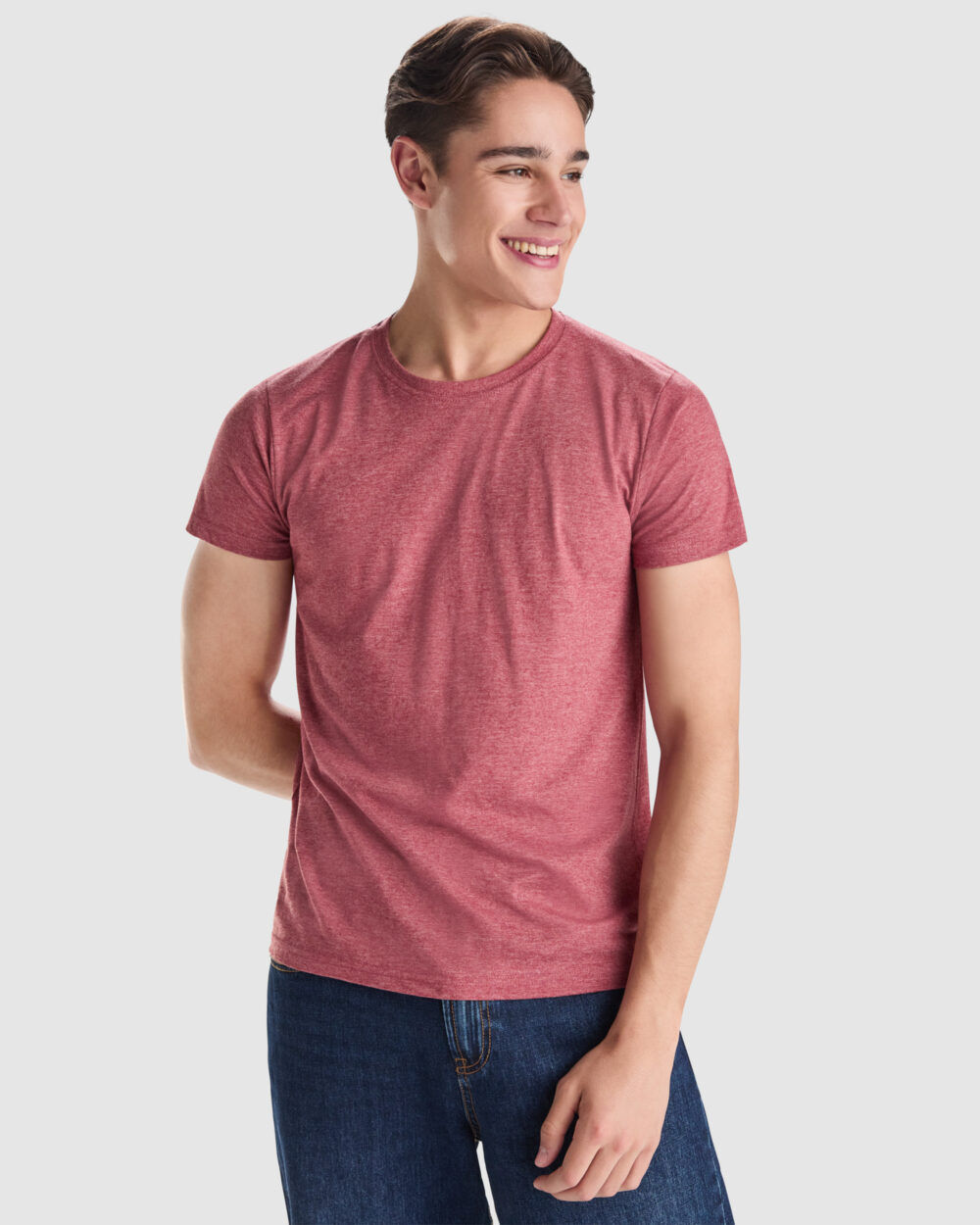 Joven sonriente con camiseta roja y vaqueros