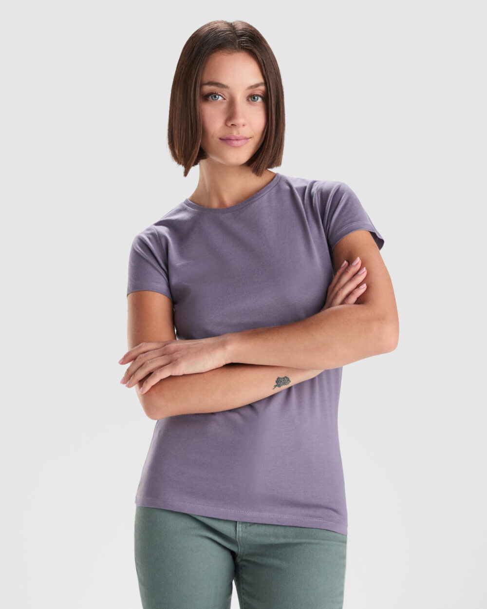 Mujer con camiseta morada y brazos cruzados
