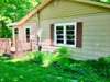 A quaint deck attached to the side door entrance.  Home has storm doors both front & side as well as vinyl wrapped eves. 