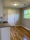 View of the kitchen as you enter from the living-room. Door across the room leads to the backyard.