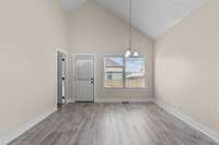 Dining room located off the kitchen with vaulted ceiling and large window