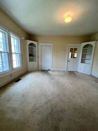 Formal Dining room with built in china cases and beautiful windows. Also has original swinging butlers door into the kitchen. 