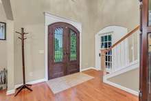 Impressive iron front doors welcome you into the bold entryway with tall ceilings and staircase. 