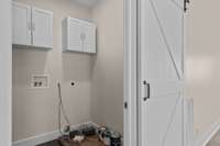Utility room with built in cabinetry for storage and washer/dryer hook up