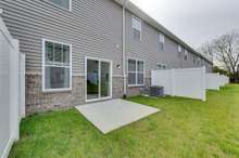 Back of home with patio space and partial fence  *Photo of decorated model