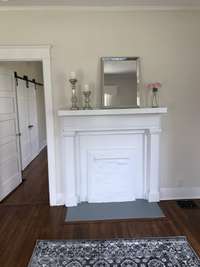 Living room with hardwood flooring , recessed lighting, and original mantle for hanging Christmas stockings 