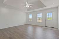 Spacious living room features a tray ceiling, new flooring and freshly painted walls. 