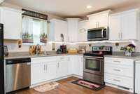 The Kitchen has Shaker-style soft-close cabinets & drawers, stainless steel Dishwasher, Stove & Microwave (and black refrigerator) which all remain with the home!