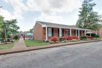 Community club house with a small picnic area and the community pool just behind