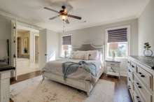 Primary bedroom suite on the main level of the home with upgraded wood floors