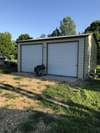 Garage/shop has 10 ft. doors, concrete floor, small woodstove, and a refrigerator that will remain with property.