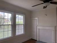 Main floor bedroom , hardwood flooring and original mantle 