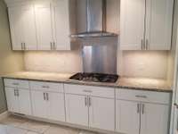 Five burner gas stove top, super fan hood and cabinet storage galore!