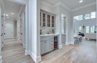 There is a wet bar with a sink and ice maker as you enter the kitchen on the left and across from the dining room.